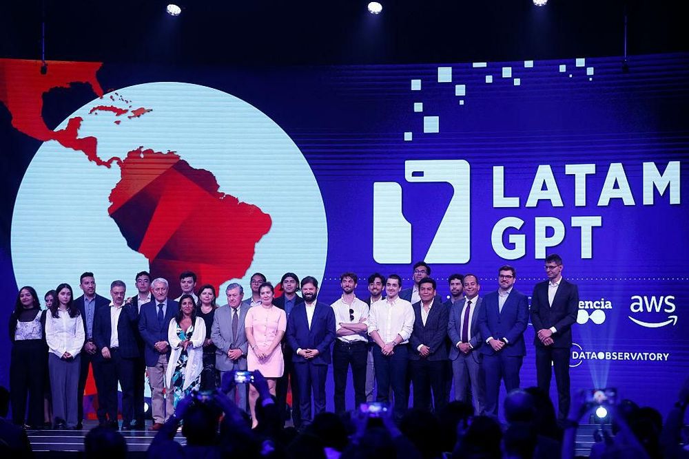 A large group of people stand on a stage in front of a screen displaying 'LATAM GPT' and a map of Latin America.