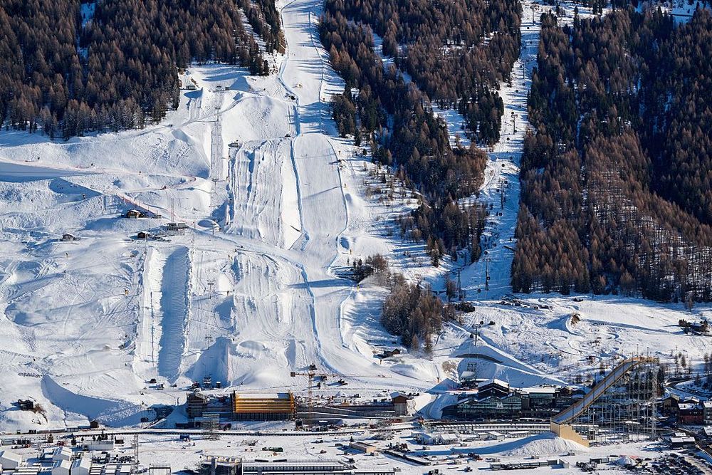 Aerial view of a large winter ski resort with multiple snow-covered slopes and dense pine forests.
