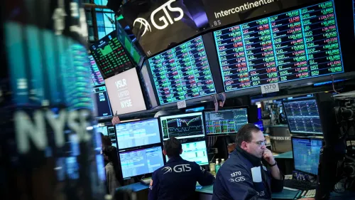 Traders monitor financial data on numerous screens on a bustling stock exchange floor.