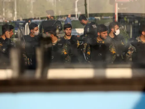 Group of young men in dark uniforms and face masks standing outdoors.