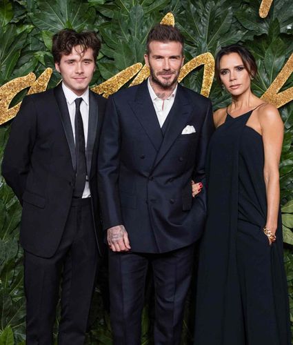 David Beckham, Victoria Beckham, and their son Brooklyn pose at a formal event.