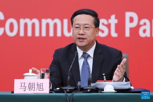 Chinese diplomat Ma Zhaoxu speaks at a press conference against a red backdrop.