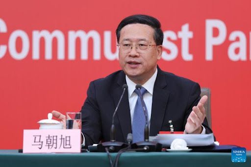Chinese diplomat Ma Zhaoxu speaks at a press conference against a red backdrop.